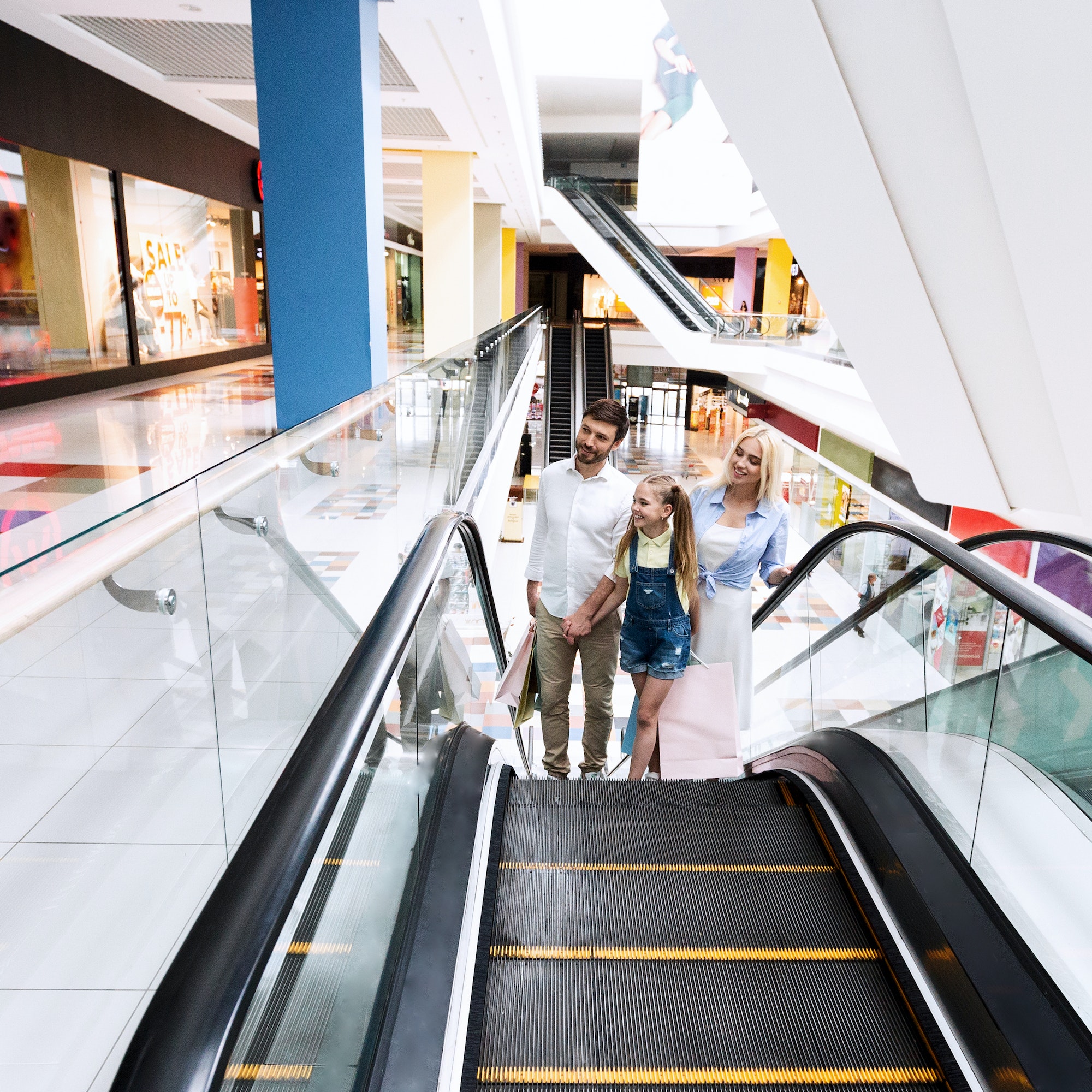 Family On Shopping Moving Up On Escalator Stairs In Hypermarket